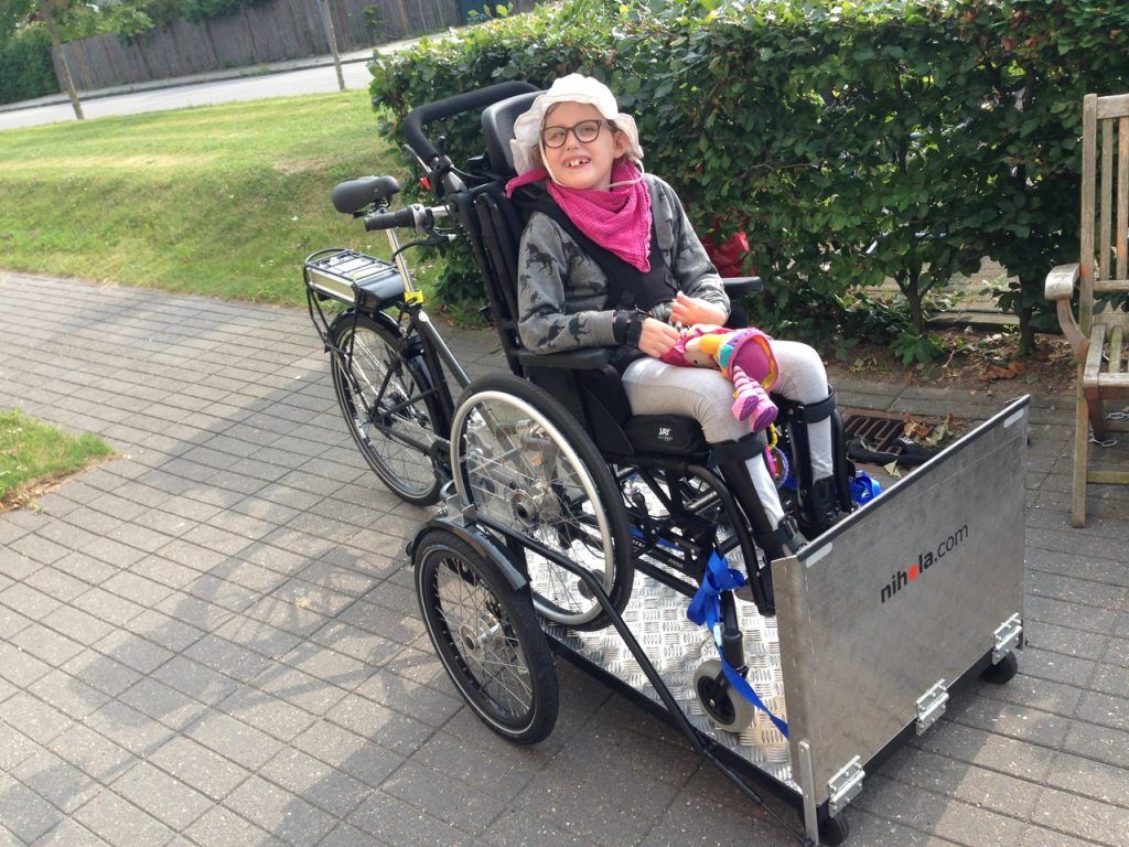 Osoba na wózki inwalidzkim jedzie rowerem